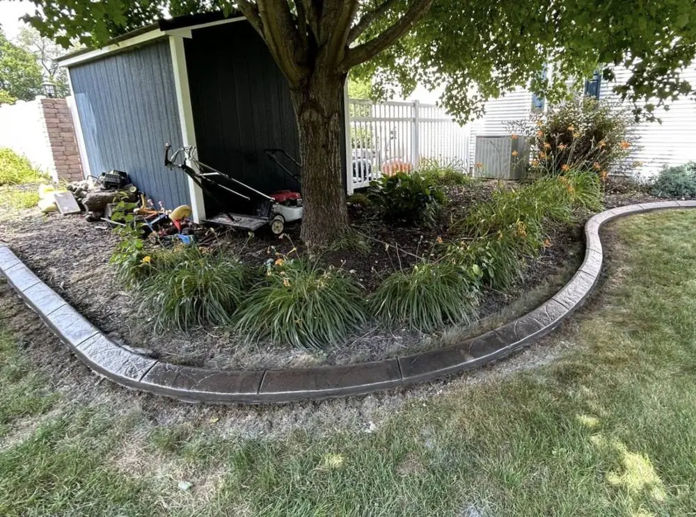 Stamped concrete landscape curbing poured in a continuous run around a tree bed